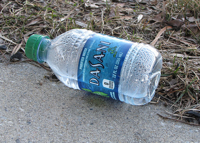A Dasani water bottle lying on the ground, illustrating marketing campaigns and branding strategies.
