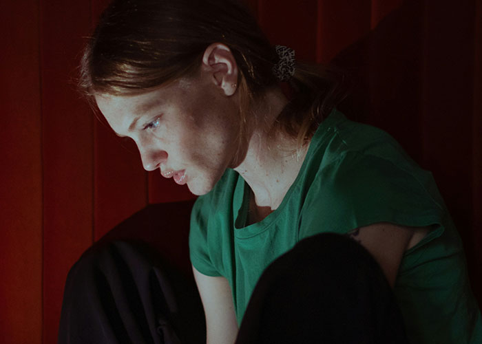 Young woman in green shirt focused on screen, illustrating powerful marketing campaigns with subtle emotional impact.