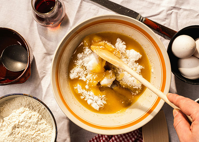 Hands mixing ingredients in a bowl with eggs, flour, and vanilla, illustrating marketing campaigns concept.
