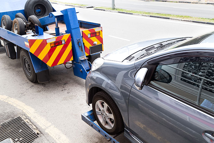 Car being towed by a blue tow truck as man claims he&rsquo;s doing property shepherd a favor by not moving his vehicle