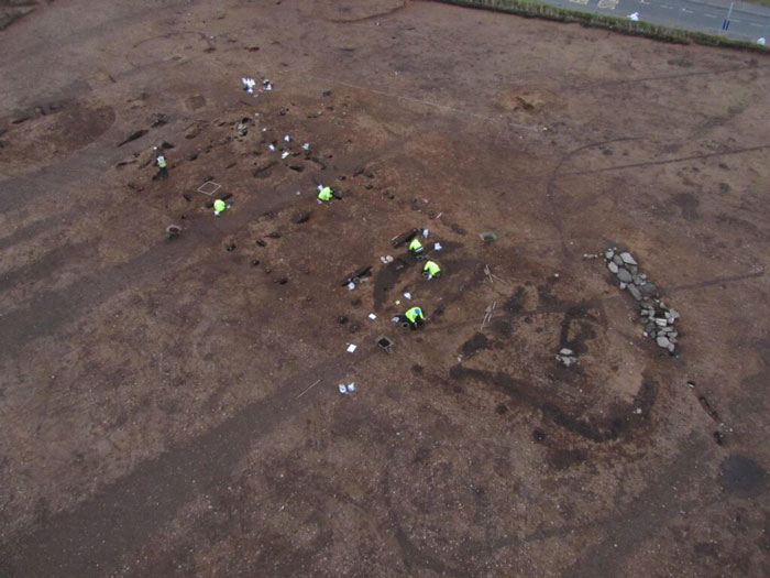 Aerial view of archaeological excavation uncovering Neolithic halls beneath Scottish school grounds older than Stonehenge.