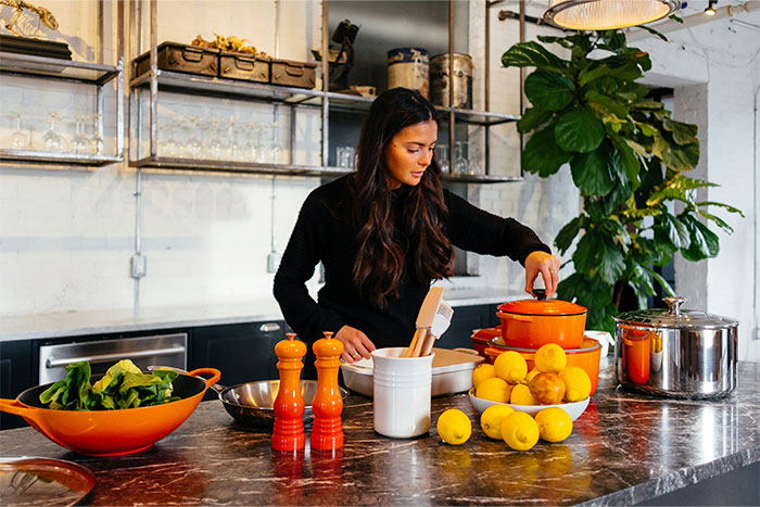 Woman in a modern kitchen preparing food with fresh ingredients and cooking secrets shared by 60 people. - 18