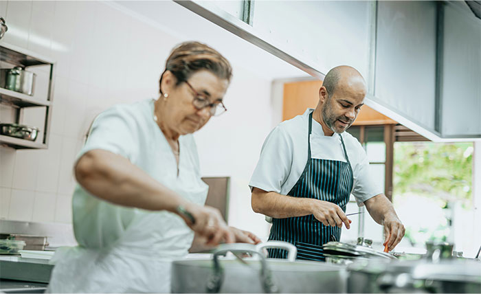 Two chefs in a professional kitchen sharing cooking secrets and unique ingredients while preparing food together. - 30