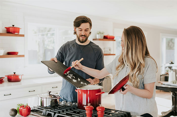 Couple cooking together in a bright kitchen using cooking secrets and ingredients not usually revealed. - 26