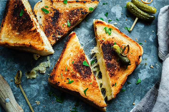 Grilled cheese sandwich with melted cheese and fresh herbs, showcasing cooking secrets and unique ingredients. - 36