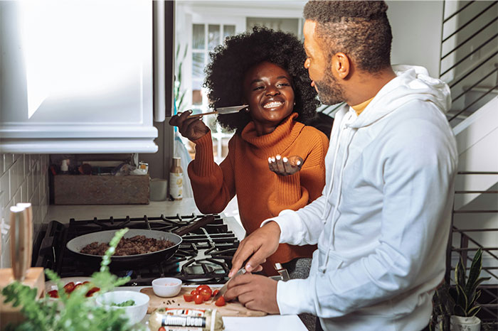 Couple sharing cooking secrets in a modern kitchen, preparing ingredients and enjoying the cooking process together. - 40