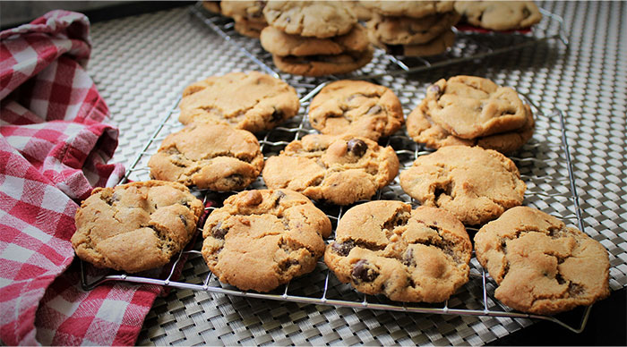 Freshly baked chocolate chip cookies cooling on a rack, illustrating cooking secrets and unique ingredients shared. - 48