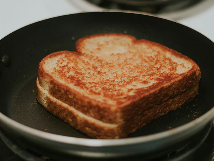 Golden grilled sandwich cooking in a black pan revealing simple cooking secrets and ingredients for a perfect toast. - 42