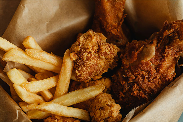 Close-up of crispy fried chicken and golden French fries in a basket, showcasing cooking secrets and unique ingredients. - 49