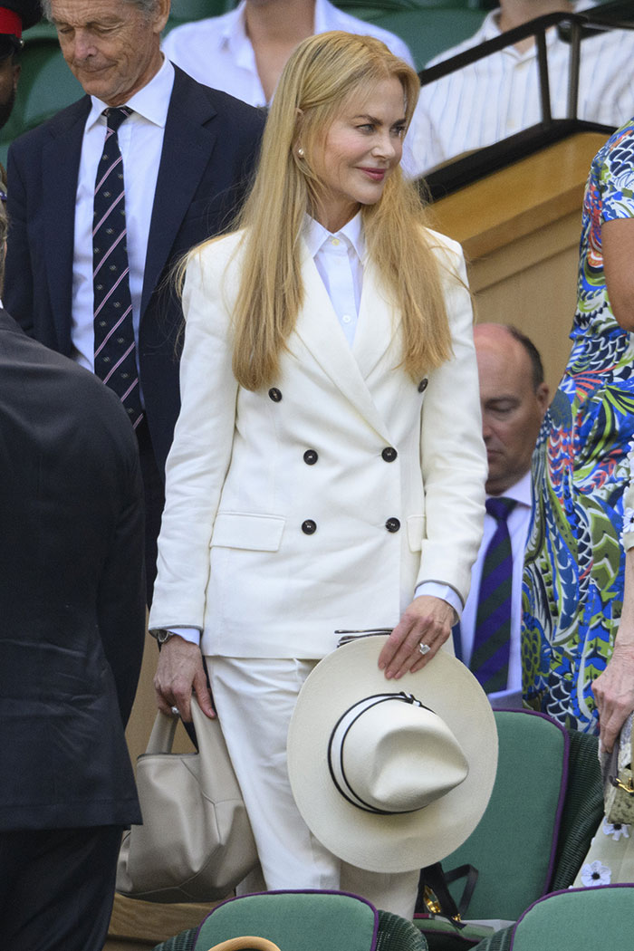 Nicole Kidman at Wimbledon 2025 wearing an elegant white suit and holding a matching hat during the celebrity looks event.