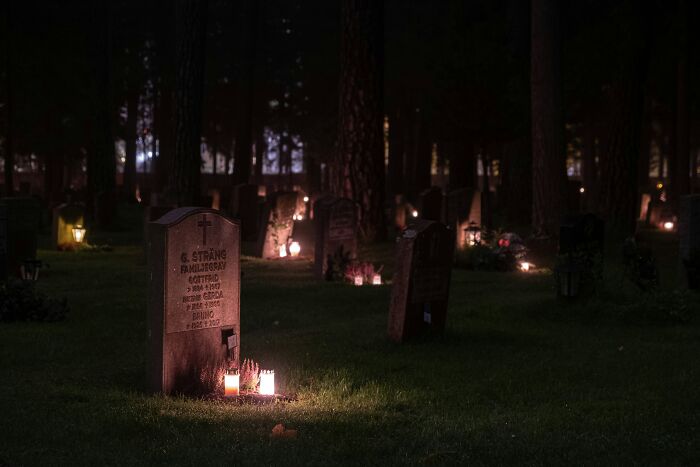 Graveyard at night illuminated by candles, reflecting the quiet setting of night shift workers and overnight benefits. - 20