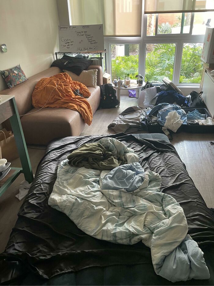 Messy room with unmade bedding, cluttered floor, and couch reflecting bad roommate stories and solutions from Reddit.