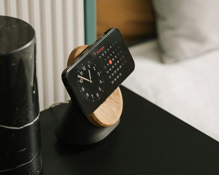 Smartphone on a stand showing time and calendar, symbolizing night shift workers managing overnight schedules effectively. - 26