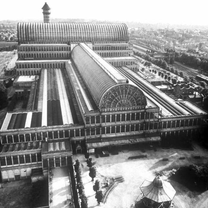 Historic old architecture featuring large glass and iron structures with intricate design in an urban setting.