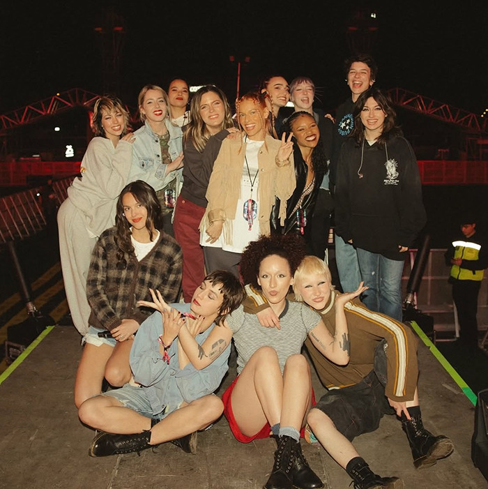 Olivia Rodrigo with her crew posing together outdoors at night, highlighting her caring gesture for the team. Olivia Rodrigo with her crew posing together outdoors at night, highlighting her caring gesture for the team.