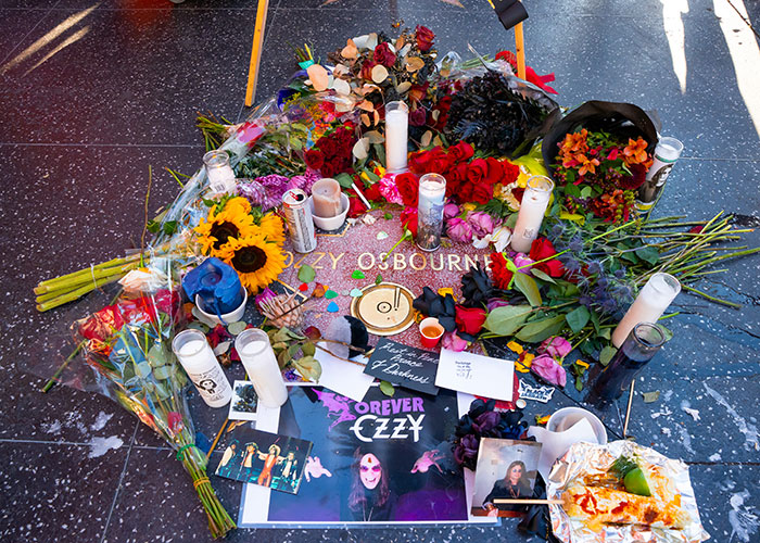 Memorial of flowers, candles, and tributes surrounding Ozzy Osbourne&rsquo;s star, reflecting Black Sabbath&rsquo;s emotional statements.