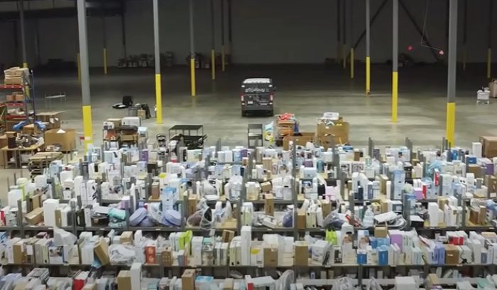 Large warehouse filled with hundreds of Amazon packages mistakenly delivered and stacked in rows. Large warehouse filled with hundreds of Amazon packages mistakenly delivered and stacked in rows.