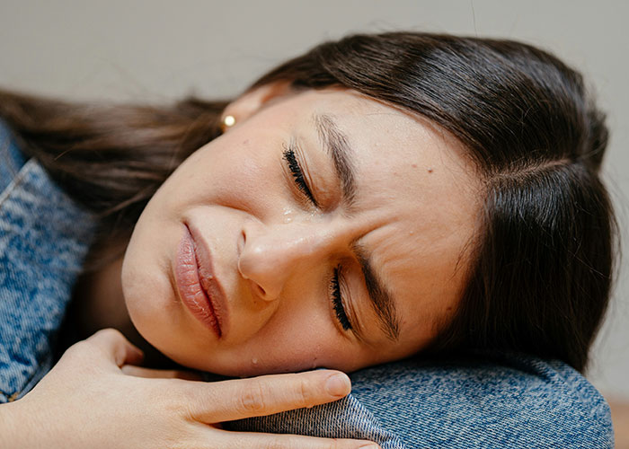 Close-up of a woman crying and upset, illustrating feelings of struggle and family financial inequality.