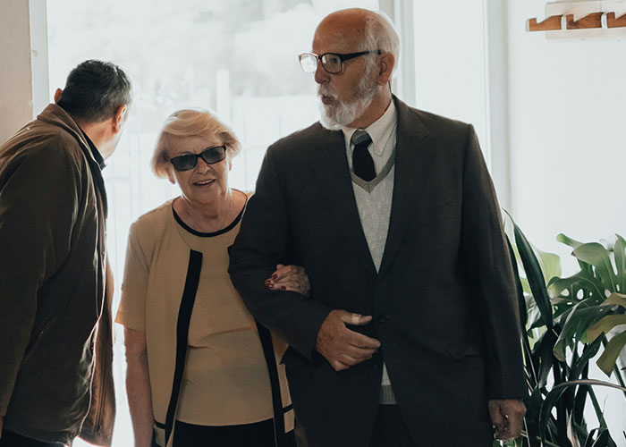 Older parents entering a home with adult children, illustrating family dynamics after financial gifts to one sibling causes struggle.