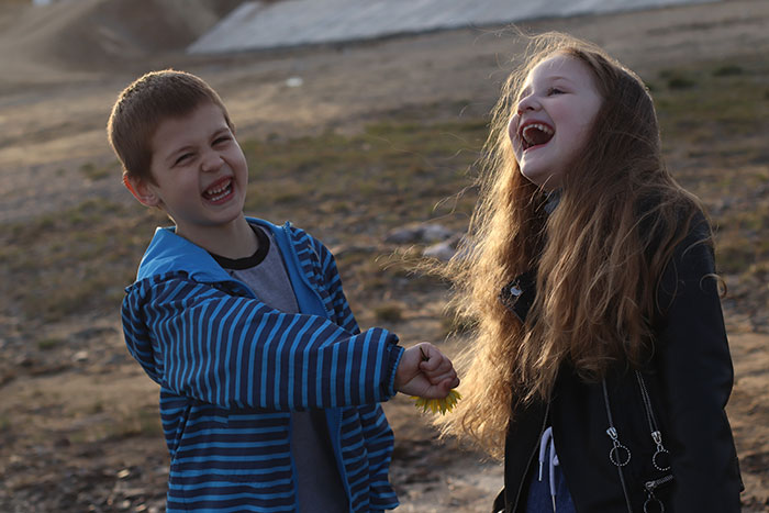 Two children laughing outdoors, highlighting themes of bio son and adopted kids family dynamics. - 17