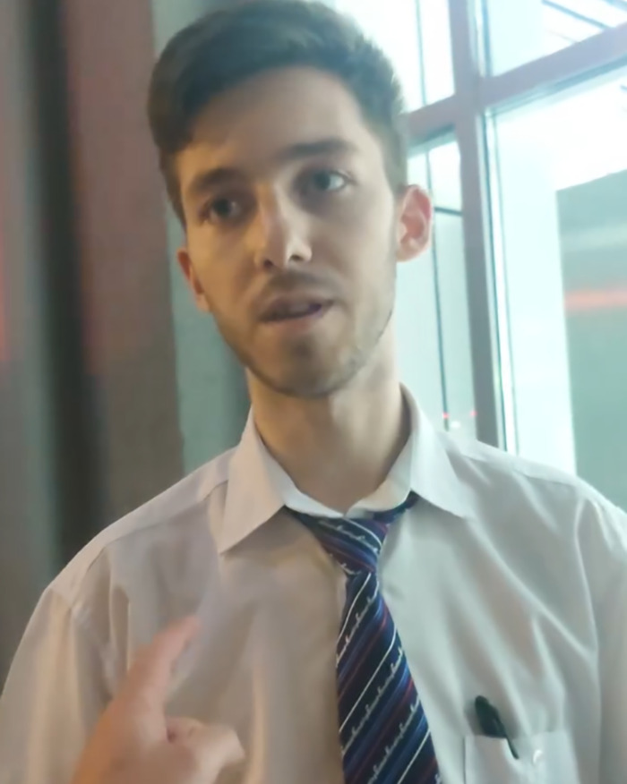 Young man in a white shirt and striped tie showing a frustrated expression after Ryanair passenger luggage size dispute. - 3