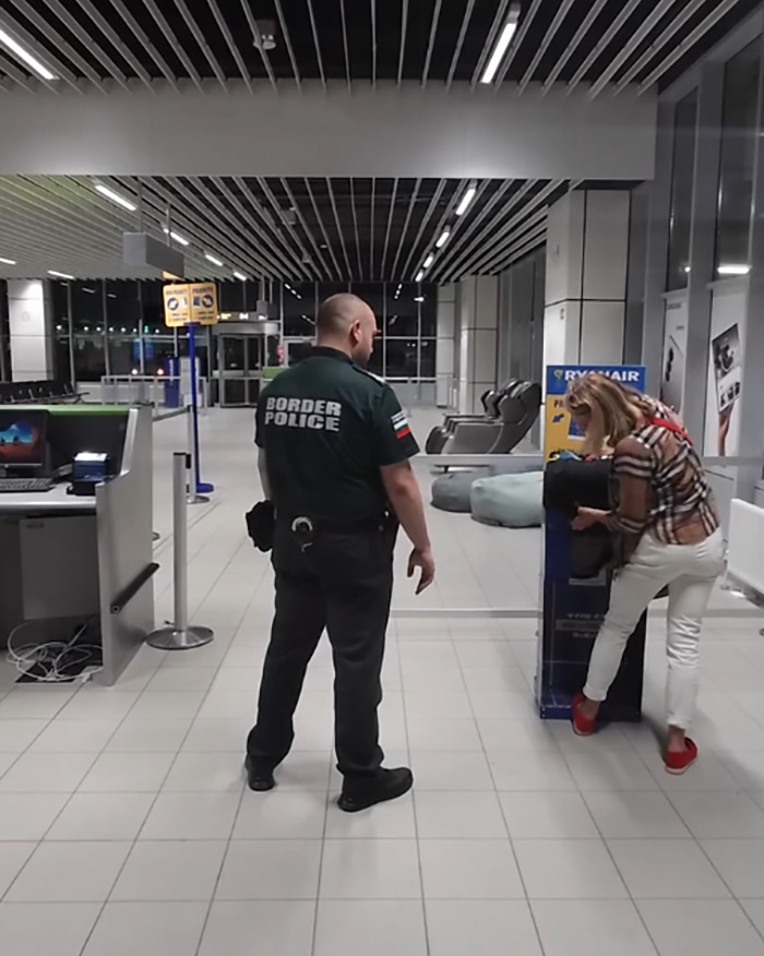 Passenger measures luggage at Ryanair checkpoint while border police officer observes in an airport setting. - 6