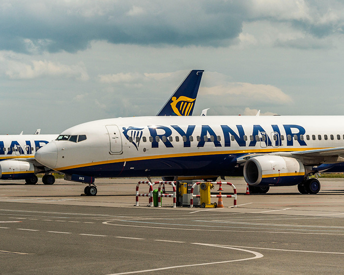 Ryanair airplane parked on the tarmac under cloudy sky representing passenger denied boarding over luggage size issue. - 11