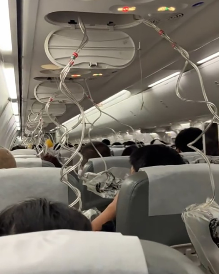 Passengers wearing oxygen masks inside Japan Airlines flight cabin during sudden mid-air plunge emergency. Passengers wearing oxygen masks inside Japan Airlines flight cabin during sudden mid-air plunge emergency.