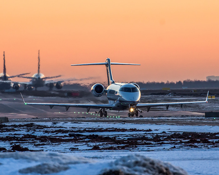 Private jet taxiing on snowy runway at sunset, related to Japan Airlines flight sudden plunge incident. Private jet taxiing on snowy runway at sunset, related to Japan Airlines flight sudden plunge incident.