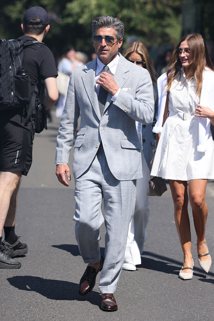 Man in a light gray suit and sunglasses walking at Wimbledon 2025, showcasing celebrity looks and stylish fashion trends.