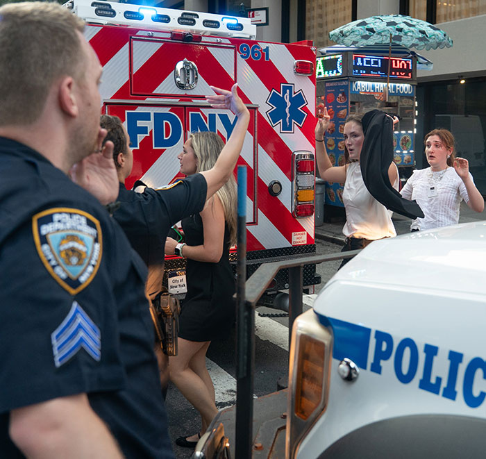 Police and emergency responders at Manhattan street scene, with civilians reacting near FDNY ambulance and police vehicle after massacre incident. - 10