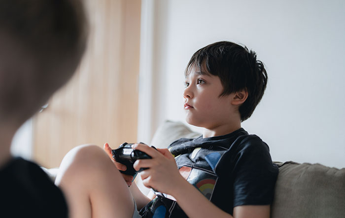 Young boy focused on playing video games, illustrating moments when people had enough and took action. - 36