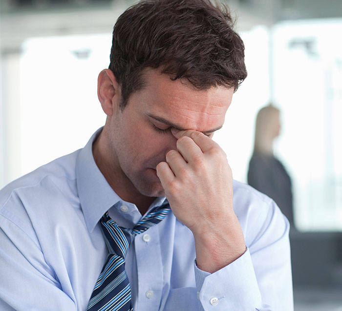 Stressed man in office wearing loosened tie, appearing overwhelmed and ready to take action after having enough. - 32