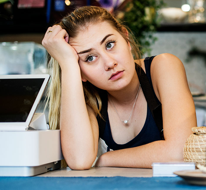 Young woman looking frustrated and tired, taking a break at a small business counter, showing enough and action taken. - 7