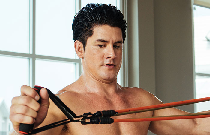 Man exercising with resistance bands indoors showing determination and strength in a moment people had enough and acted - 37