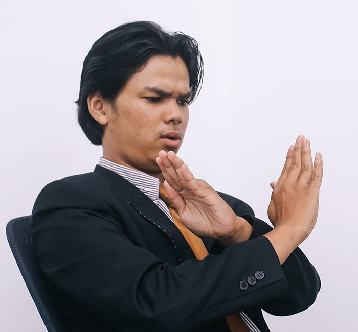 Young man in a suit showing a stop gesture with his hands, expressing he has had enough and took action. - 38
