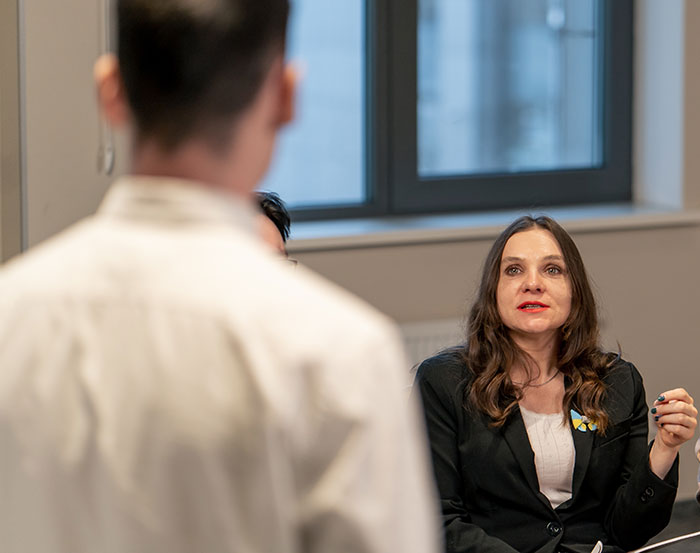 Woman engaged in a serious discussion with a man in a professional setting showing people had enough and took action. - 2