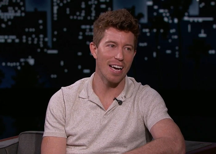 Man in a light-colored polo shirt speaking during a late night talk show about celebrities from school.