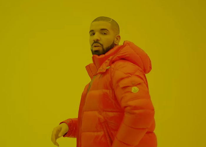 Man in red puffer jacket posing against a solid yellow background, illustrating celebrities who share school memories.