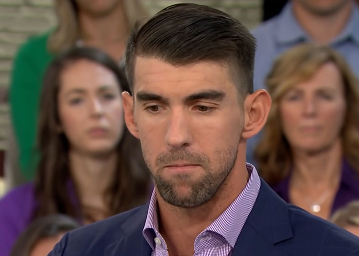 Man in a suit speaking thoughtfully in an interview about people who went to school with celebrities experiences.