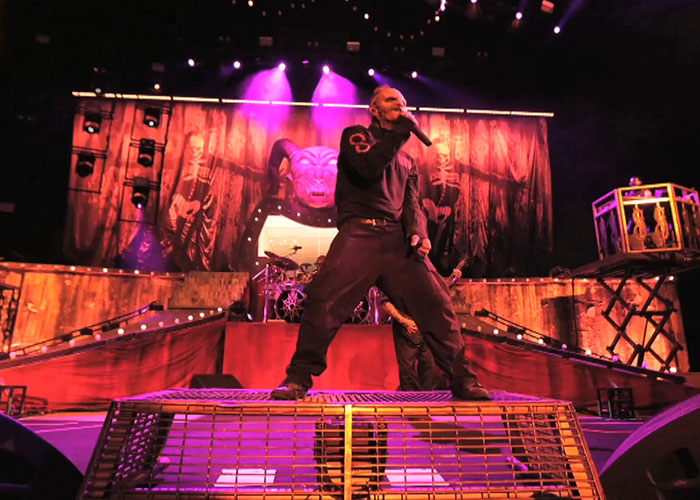 Performer on stage during a live concert with dramatic lighting showcasing celebrities and entertainment moments.