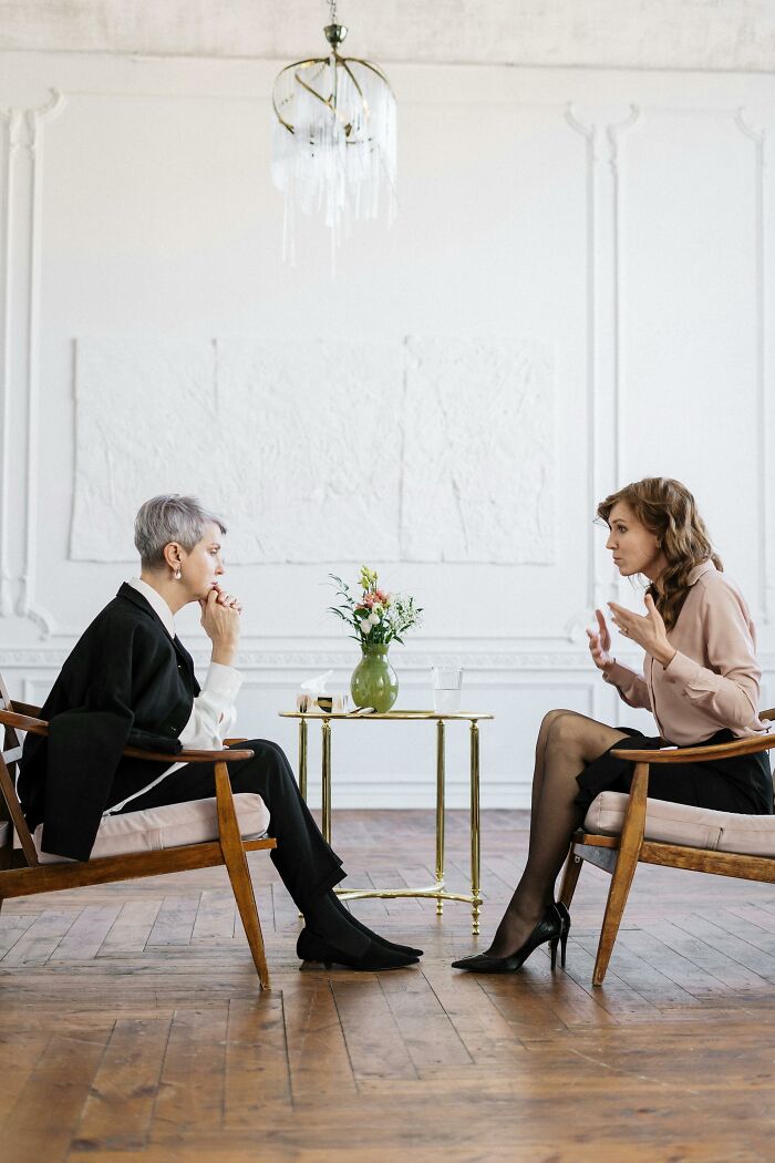 Two women in a serious conversation in a minimalist room, reflecting sad brutal and discouraging truths about life. - 4