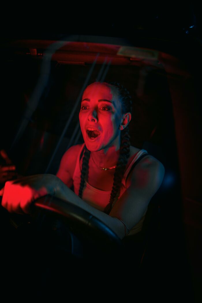 Woman showing intense emotion while driving at night, illustrating a fascinating psychology experiment on human reactions.