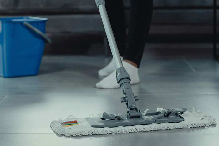 Worker mopping floor showing courage to call out bosses, reflecting on workplace challenges and outcomes.
