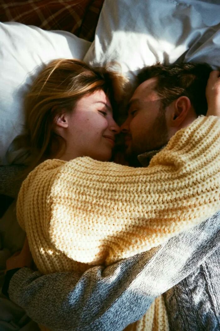 Couple lying in bed embracing closely, illustrating intimacy and potential cheating red flags in relationships. - 37