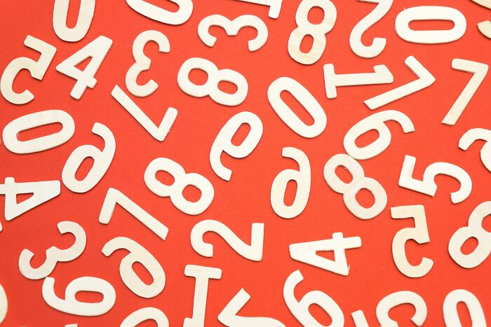 Scattered white numbers on an orange background representing general knowledge questions with numbers to type answers.