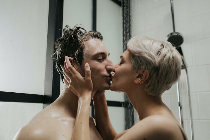 Couple sharing a close kiss in a shower, illustrating romantic red flag behaviors often misunderstood in relationships. - 23