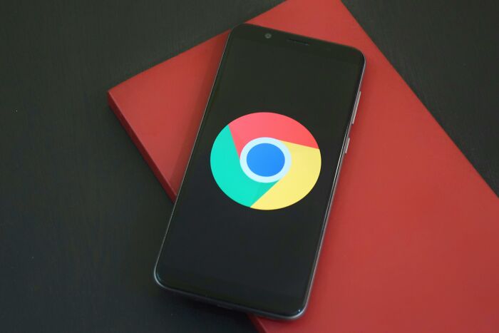Smartphone displaying Chrome logo placed on a red book, representing digital content related to pickup lines.