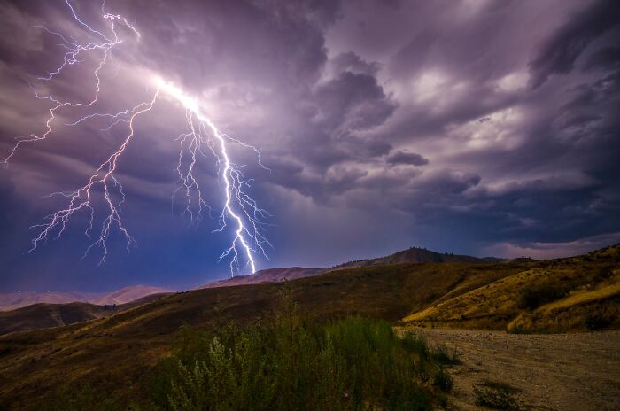 Lightning striking over a hilly landscape under stormy skies illustrating survival tips that won't help in real emergencies.