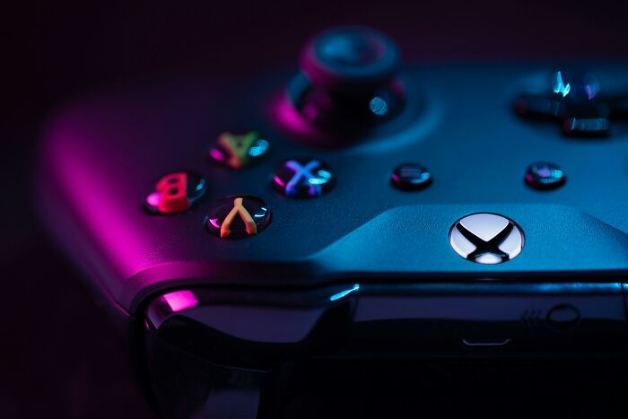 Close-up of a gaming controller lit with purple and blue lights, illustrating pettiest things in breakups.